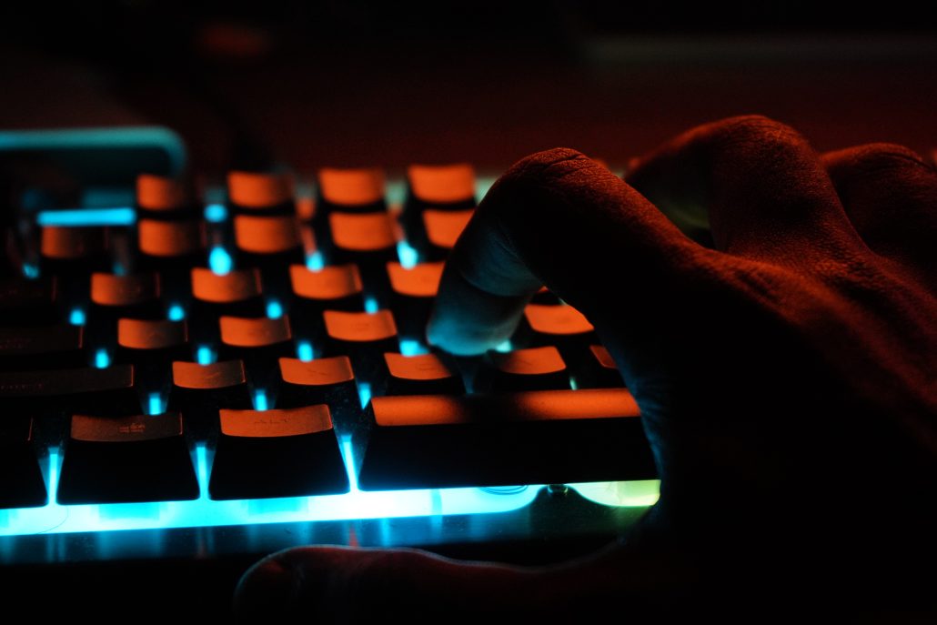 Image of a hand typing on a backlight keyboard